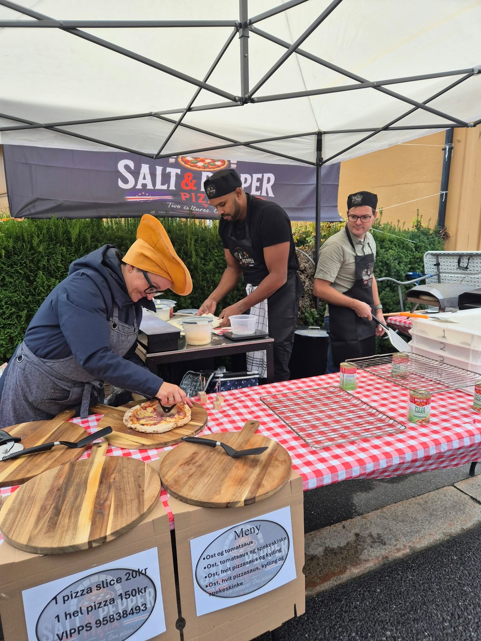 Pizzakokkene lager fersk pizza ved boden