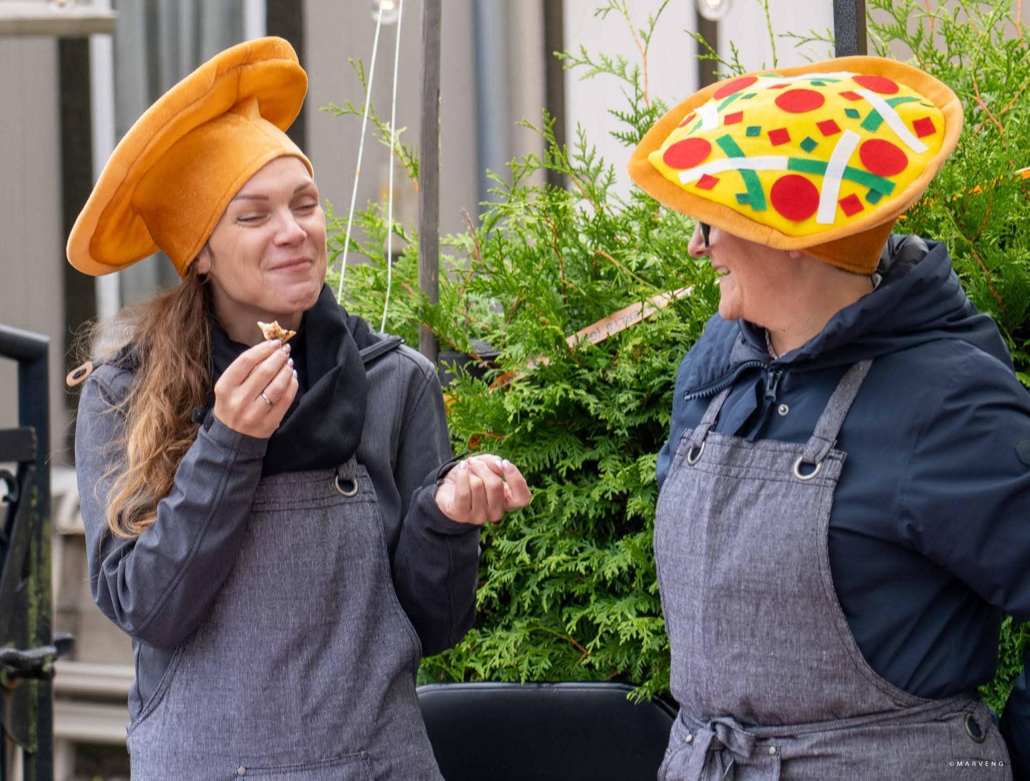 To av deltakerne smaker på pizza under markedet